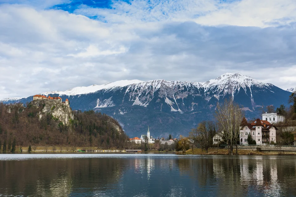 A lake, mountains and waterfront buildings beneath an open sky